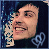 Pixelated close-up of a smiling person with dark hair against a blue background with white text and symbols.