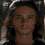 Four identical pixelated headshots of a person with long brown hair and light skin arranged in a against a dark background