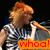 A person with red hair in a striped shirt holds a microphone, displaying text overlays that change across four