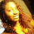A woman with long curly brown hair and a golden-brown skin tone appears in a of four , each showing a slightly different pose and expression