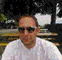 nine identical pixelated images showing a person in a white shirt and sunglasses against a blurred outdoor background with trees and yellow lines