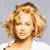 Pixelated static image of a person with curly light brown hair against a gray background, rendered in low-resolution 50x50 pixels with visible dithering and color blending.