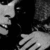 Black-and-white animated sequence showing a person's face and hand in close-up, with subtle movement across frames.