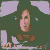 A pixelated image of a person with dark hair and light skin, wearing a brown top against a green background.