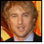 Pixelated image of a person with light brown hair wearing a dark jacket over a light shirt against an orange and yellow background.
