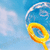 Pixelated blue background with white cloud shapes and a yellow-orange circular object with a tail on the right side.