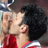 Static 48x48 pixel icon showing two figures in a close embrace with one figure kissing the other's cheek, wearing red and white clothing against dark hair and background.