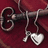 A pixelated key with heart and small charm pendants on a maroon background, surrounded by red text in four sections.
