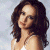A pixelated image of a woman with long brown hair wearing a white top, positioned next to green text on a dark background.