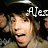 Pixelated image of a person with brown hair wearing dark clothing, partially obscured by white text reading "Alec" on the right side.