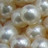 Pixelated static image with scattered light and dark patches in muted brown, gray, and white tones forming an indistinct pattern.