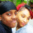 Two pixelated faces in close proximity, one wearing a red headband and dark clothing against green foliage background.