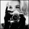 Black-and-white image of a person holding a camera with both hands, taking a photo; the right frame shows the flash firing.