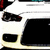 White vehicle front with black headlights and grille, red accents on top corners, static image.