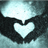 Two dark hands form a heart shape around a glowing light source against a gradient background.