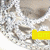 A circular silver-toned object with a textured surface displays changing text overlays in yellow, blue, and green across four