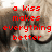 Red pixelated text reads 'a kiss makes everything better' over a blurred background with indistinct shapes.