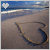 A beach scene with a heart drawn in sand, featuring a white pixelated heart icon and blue sky background across two animated frames showing subtle color variation.
