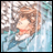 Pixelated anime-style character with light brown hair and red lips, wearing a blue garment against a blurred background with white and blue tones.