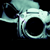 Pixelated cyan and black skull icon with hollow eye sockets and nasal cavity, rendered in low-resolution digital style against solid black background.