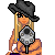 Pixelated character with blonde hair and black hat holding microphone, transitioning from static pose to text overlay with 'Get The' and 'Outta My Way!' phrases.