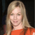 Static pixelated image of a person with long blonde hair wearing an orange top against dark background.