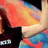 A person in a black top and blue patterned garment holds an orange-yellow object, with 'XLTB' text visible on the image.