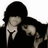 Pixelated image of two figures in dark clothing with light hair, positioned closely together under orange text reading VAMPIRE KISSES.