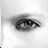 A grayscale pixelated image of a single human eye with visible eyelashes and subtle shading, set against a plain white background.
