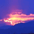 A pixelated image of a glowing, elongated object with a bright yellow core and pinkish-orange edges against a blue background.