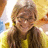 A pixelated image shows a person with long brown hair wearing a yellow top, next to bright pink text on a solid yellow background.