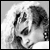 Pixelated grayscale image of a person's face with visible facial features and hair, rendered in low resolution with dithering effects on a light background.