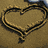 Animated sequence showing a heart drawn in sand, followed by two figures walking on a beach with reflections.