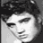 Black-and-white pixelated static icon of a person's face with dark hair, visible eyes, nose, mouth, and facial features rendered in grayscale tones on a transparent background.