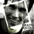 Pixelated grayscale portrait of a smiling person with dark hair and a light-colored shirt, cropped to show only the upper face and shoulders.