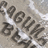 Pixelated grayscale image with dark abstract shapes resembling stylized letters or symbols scattered across a light background with white highlights.