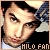 Pixelated close-up of a person's face with dark hair, wearing a white shirt and black jacket, against a light background with text reading 'HILO FAN' at the bottom.