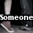 Two pairs of legs in dark pants and brown sneakers with white soles, standing on a gray surface against black background, text overlays read "Someone that I love".