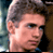 Pixelated close-up of a person's face with short light brown hair, visible ear, and partial shoulder in low-resolution static image.