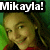 Pixelated image of a person with light brown hair and green eyes, wearing red clothing against a green background with text reading "Mikayla!" at the top.