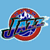 Pixelated circular icon with red outer ring, blue and white central design featuring a stylized 'S' shape on light blue background.