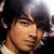 A pixelated image of a person with dark hair and light skin, next to yellow background text reading "I love Joe Jonas <3333".
