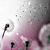 Pixelated static image with pink and white gradient background, scattered dark gray squares, and two black vertical shapes resembling stylized letters.