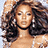 Pixelated image of a woman with long dark hair and light skin, wearing large earrings and a white top, positioned next to red text on brown backgrounds.