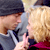Pixelated static image of two figures in close proximity with one figure's hand near the other's face, featuring muted colors and low-resolution rendering.