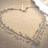 A heart-shaped sand drawing with text changing across frames: 'i', then 'love', then 'jake<3'.