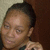 A static pixelated image shows a person with short dark hair, light skin tone, and closed eyes against a two-toned background.