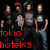 Four people stand in a with red text below them; the rightmost person's face is blurred