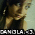 Pixelated image of a person with dark hair and light skin, wearing a dark top, with text at the bottom reading "DAMI3LA.<3.".