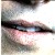 A pixelated close-up of a person's face showing eyes, nose, and mouth with visible skin tones and dark hair against a light background.